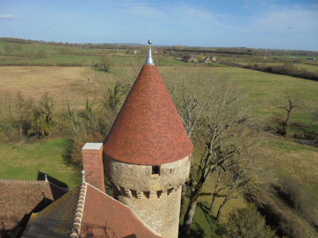 Toiture en petites tuiles plates de terre cuite sur tour ronde au château de Celon (Indre)