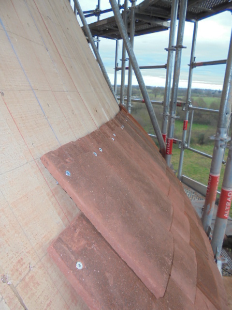 Tuiles gironées vissées sur les voliges en peupliers des tours rondes