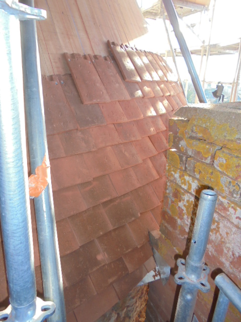 Raccord d'étanchéité entre cheminée en briques et toiture ronde